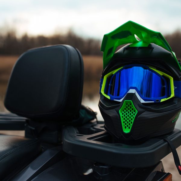 a hard-wearing green ATV helmet in the background the river and the sand. sport and extreme concept